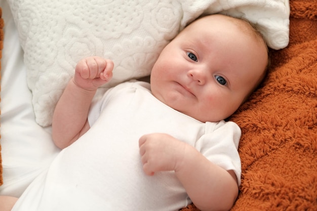 Neugeborenes Baby liegt auf dem Bett Baby spielt auf dem Bett