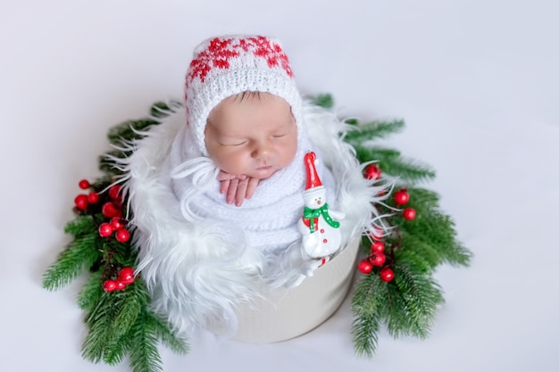 Neugeborenes Baby schläft im Weihnachtszubehör auf weißem Hintergrund