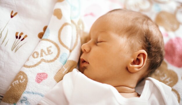 Neugeborenes Baby schläft in der Krippe auf einer Decke. Das Foto hat einen leeren Platz für Ihren Text