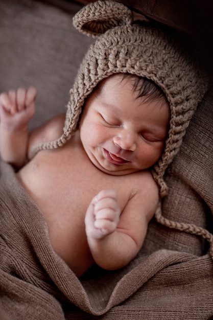 Neugeborenes Baby, schönes Baby liegt in brauner Pelzdecke auf Holz