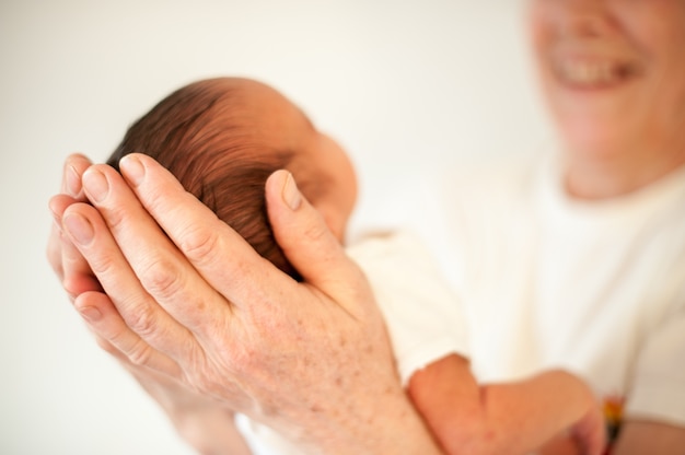 Neugeborenes Baby zuerst in den Armen