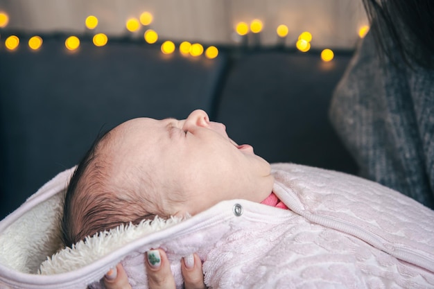 Neugeborenes Mädchen gähnt auf unscharfem Hintergrund mit Bokeh