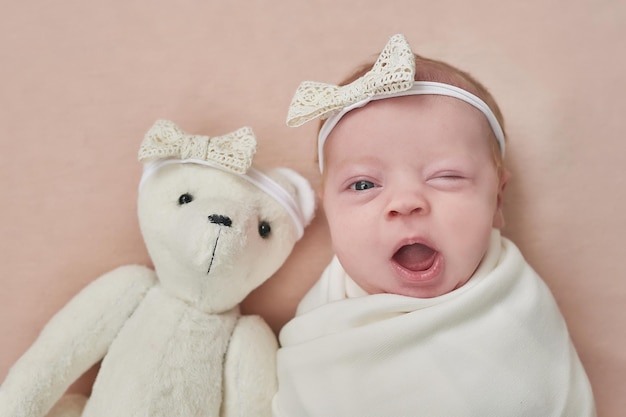 Neugeborenes Mädchen mit Spielzeugbär Gesundes Kind Glückliche Mutterschaft und Elternschaft
