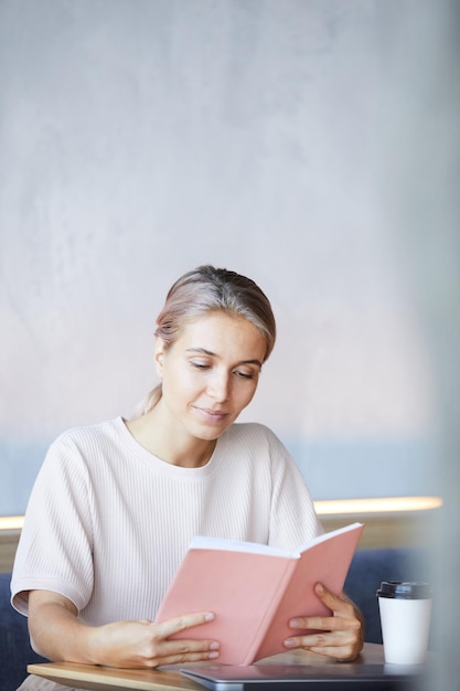 Neugierige Dame, die Zeit mit Buch verbringt