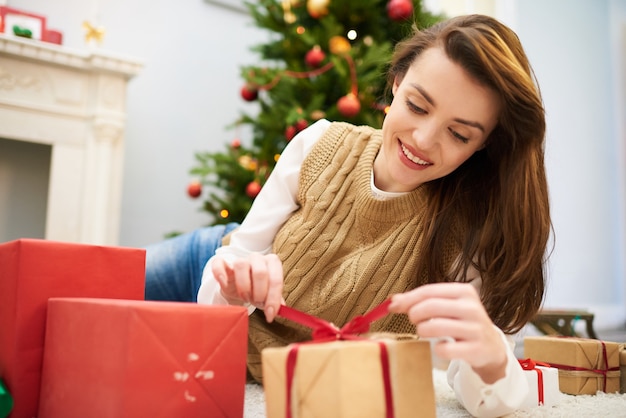 Neugierige Frau, die Weihnachtsgeschenkbox auspackt