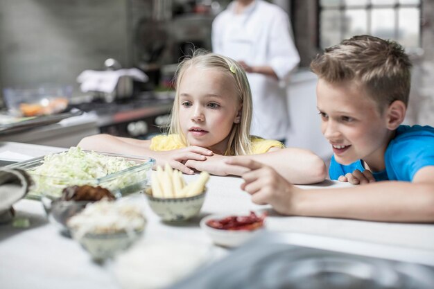 Foto neugieriger junge und mädchen in der küche