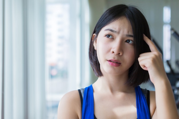 Neugieriges asiatisches Mädchen im einheitlichen Denken des Sports