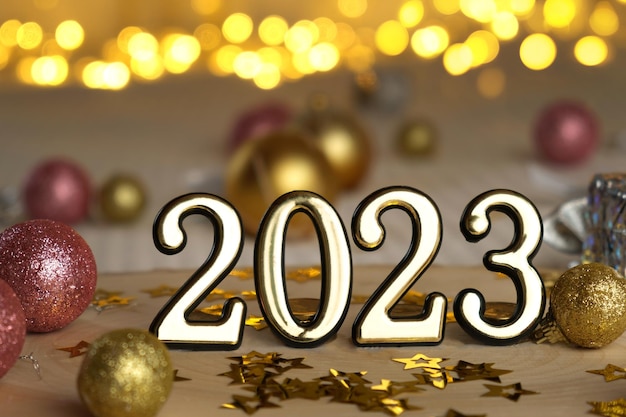 Neujahr 2023 Goldene Zahlen mit Feuerwerk verschwommen Lichter im Hintergrund Frohes neues Jahr Feiertagskarte mit Geschenken Dekorationen Bögen und Konfetti Modernes festliches kreatives Grußkartendesign