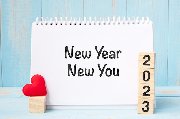 Neujahr New You Worte und 2023 Würfel mit roter Herzform Dekoration auf blauem Holztisch Hintergrund Ziel Auflösung Gesundheit Liebe und Happy Valentinstag Konzept