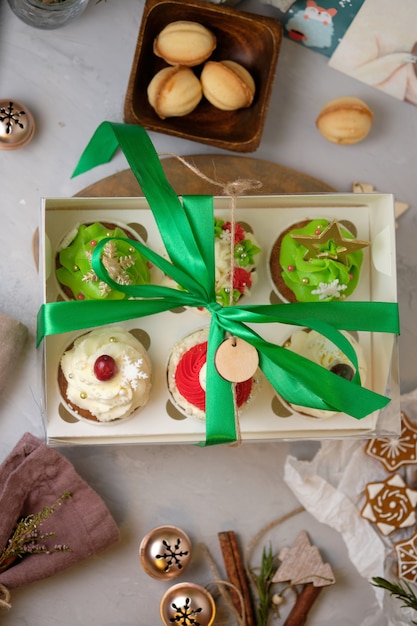 Neujahrs-Geschenksets mit Süßigkeiten. Eine Schachtel Cupcakes als Weihnachtsgeschenk. Kuchen mit Frischkäsecreme und Erdnuss-Karamell-Füllung.