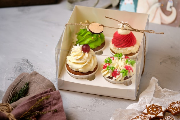 Neujahrs-Geschenksets mit Süßigkeiten. Eine Schachtel Cupcakes als Weihnachtsgeschenk. Kuchen mit Frischkäsecreme und Erdnuss-Karamell-Füllung.