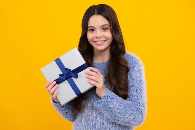 Neujahrs- oder Weihnachtsgeschenk Fröhlicher Teenager, positive und lächelnde Emotionen von Teenager-Mädchen Kind mit Geschenkbox auf isoliertem Studiohintergrund Geschenk für Kindergeburtstag