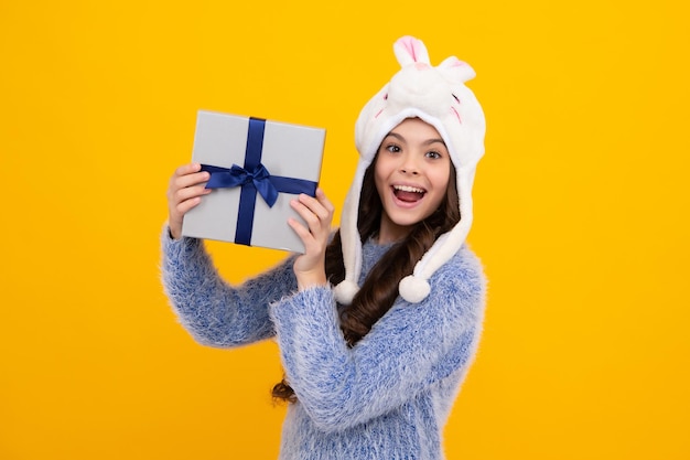 Neujahrs- oder Weihnachtsgeschenk Fröhlicher Teenager, positive und lächelnde Emotionen von Teenager-Mädchen Kind mit Geschenkbox auf isoliertem Studiohintergrund Geschenk für Kindergeburtstag