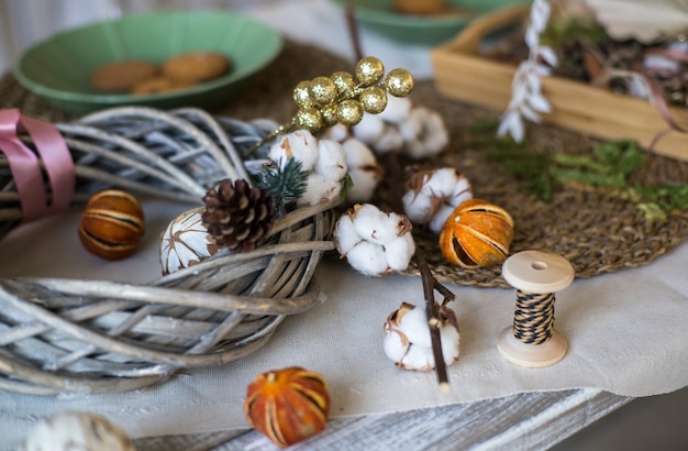 Neujahrs- oder Weihnachtskranz aus Zweigen Zimtstangen Zapfen und Weihnachtsspielzeug