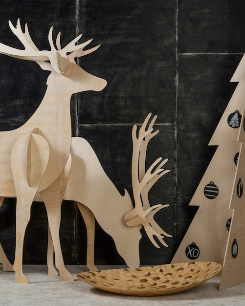 Neujahrs- und Weihnachtsdekorationen und Tannensperrholzhirsche und ein Baum auf dunklem Hintergrund