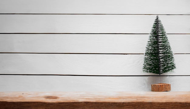 Neujahrs- und Weihnachtshintergrund mit Weihnachtsbaum auf weißem Holzhintergrund Frohe Weihnachten