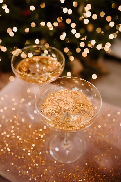 Foto neujahrsabend 20222023 feier hintergrund mit champagner champagnergläser auf glitter