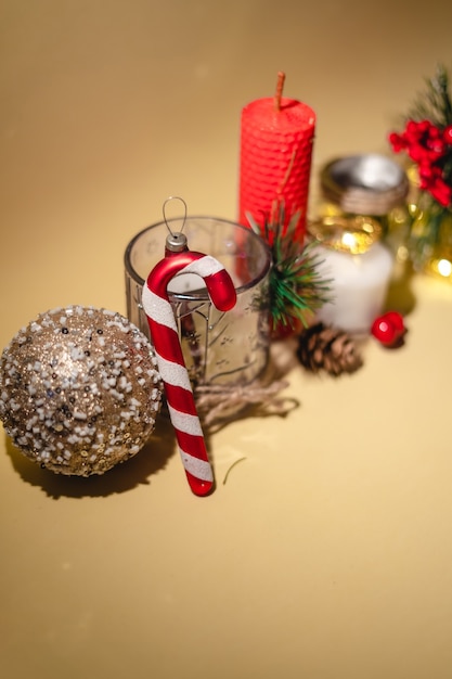 Neujahrsatmosphäre Neujahrsgeschenkkerze und Weihnachtsspielzeuggirlande auf gelbem Hintergrund
