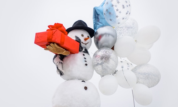 Neujahrsgrußkarte mit Schneemann Frohe Winterzeit Schneemann in Hutschalhandschuhen mit Luftballons