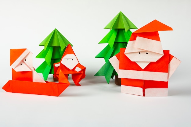 Neujahrskarte handgemachte Origami Weihnachtsmann auf einem Schlitten mit Bäumen. Weihnachtskonzept Winter gestaltete Dekorationen Studio Schuss isoliert