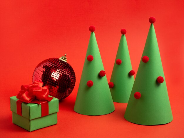Neujahrskarte Weihnachtsbaum aus Papierkugel Geschenkbox auf rotem Hintergrund Weihnachtshintergrund