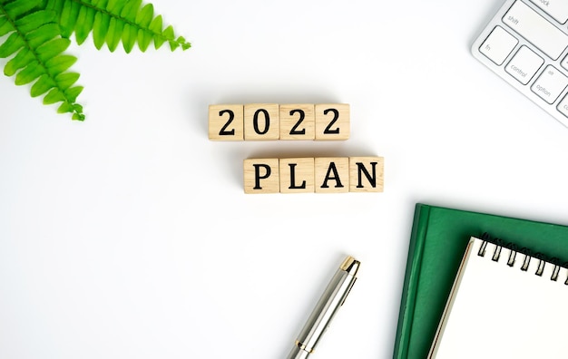 Neujahrsplan 2022 Pläne Tastatur Notizbuch und Stift 2022 PLAN Wort ist auf Holzblock geschrieben