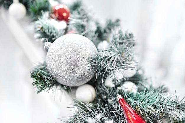 Neujahrsspielzeug auf einem künstlichen weihnachtsbaum. kugeln auf den mit schnee bedeckten fichtenzweigen