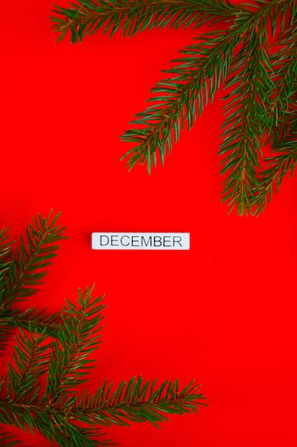 Neujahrsvorlage Weihnachtskarte Eine weiße Plakette mit der Aufschrift Dezember auf einem roten