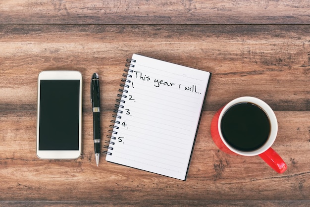 Neujahrsvorsätze Konzept Smartphone Stift und Tasse Kaffee Hintergrund
