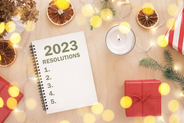 Neujahrsziele 2023 Aufgabenliste schreiben Schreiben in leeres Notizbuch am Holztisch mit Weihnachtsdekor Draufsicht Erstellen von Ziellistenauflösungen Neues Leben Start-up-Anfangskonzept Geschäftsideen