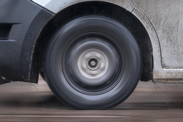 El neumático de un coche en una carretera de invierno con arena