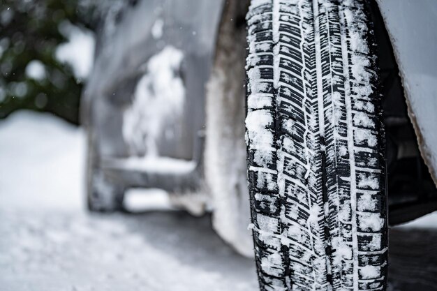 Foto neumático de invierno detalle de neumáticos de coche en invierno en la carretera cubierta de nieve