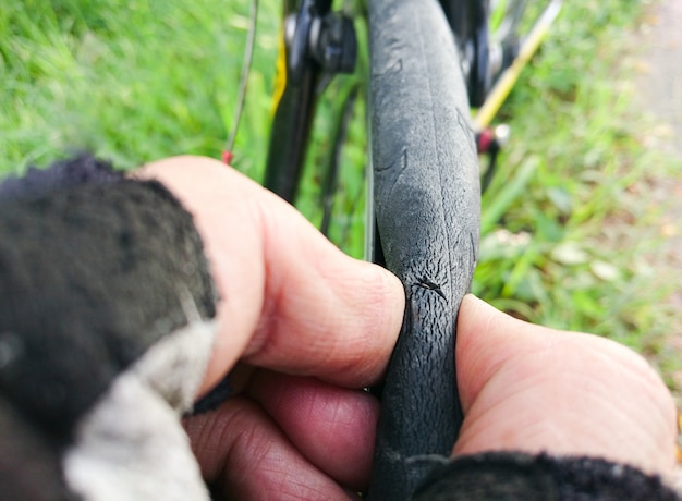 Foto neumáticos de la bicicleta aplastados debido a que el trozo puntiagudo o el vidrio roto pinchan el neumático en la carretera