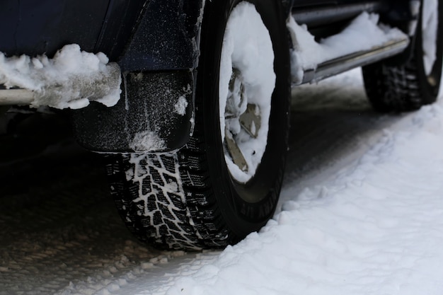 Neumáticos de invierno sobre ruedas de coche en invierno. nevadas fuera de la ciudad