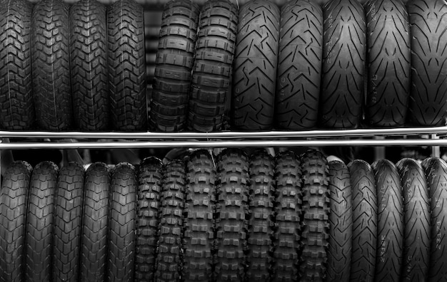Neumáticos de motocicleta en la tienda de bastidor, edición de fotos en tono oscuro