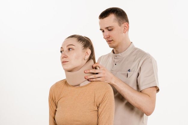 Neurocirurgião coloca colar cervical macio ou bandagem de colar cervical em mulher jovem para apoiar e imobilizar o pescoço ou para tratar lesões traumáticas na cabeça ou no pescoço Colar cervical