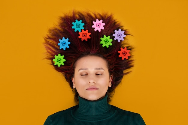 Neurophysiologie, Neurowissenschaften, Gehirn, Psychologie, psychische Gesundheit, Kreativität, Ideenkonzept. Frau mit Zahnrädern im Haar auf orangem Hintergrund.