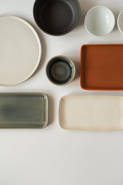 Neutrale Farbe handgefertigte Keramik leere handwerkliche Keramikplatten und Schalen auf weißem Hintergrund Flache Ansicht von oben