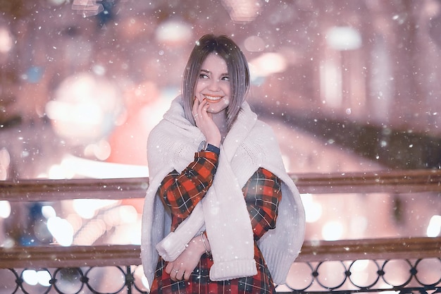 nevadas mujer ciudad navidad afuera, retrato de la ciudad en nevadas, joven modelo posando en aspecto festivo