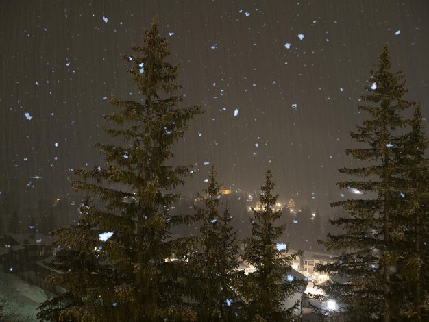 Nevando por la noche en las montañas dolomitas