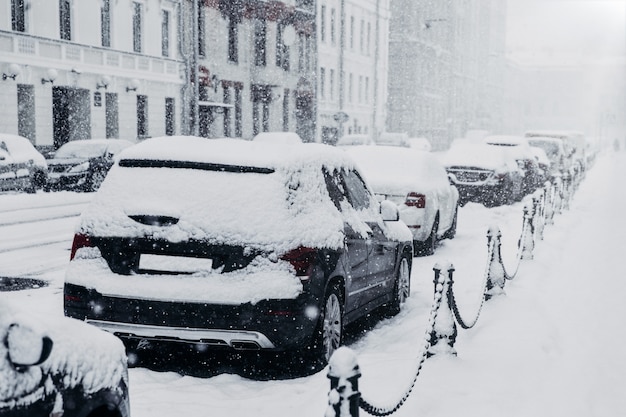 Nevasca, queda de neve pesada ou conceito de tempestade de neve. linha de carros cobertos de neve durante o inverno nevado