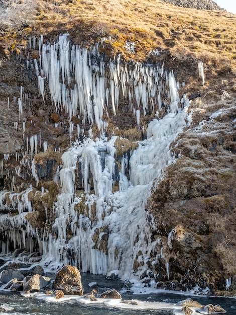 Neve congelada no penhasco da montanha na cachoeira Gluggafoss na temporada de inverno Islândia