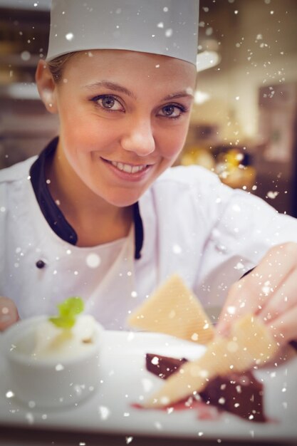 Neve contra um chef sorridente enfeitando uma fatia de bolo com bolachas