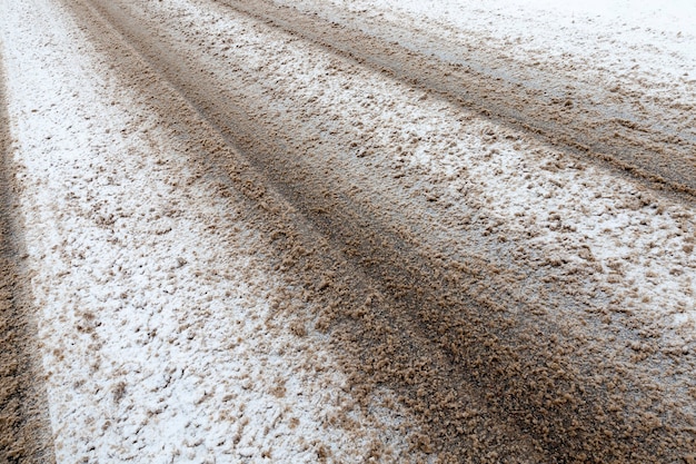 Neve suja, que imprimiu vestígios de transporte na estrada. foto tirada na temporada de inverno em um ângulo.