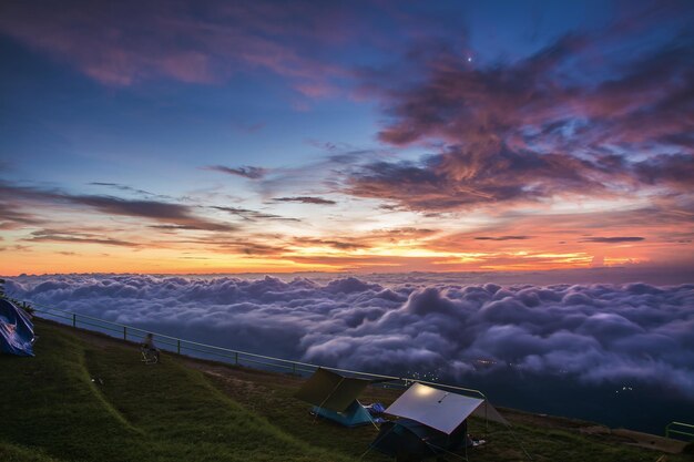 Névoa da manhã com o nascer do sol da montanha e mar de mis