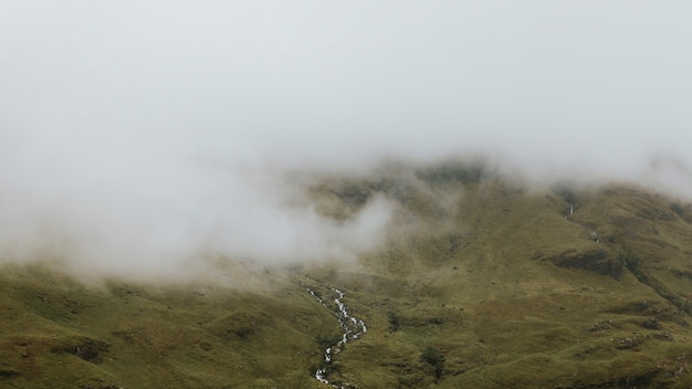 Foto nevoeiro cobrindo uma cachoeira estreita na escócia