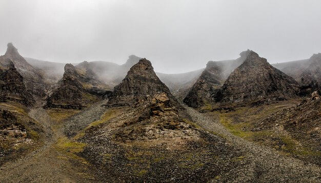 Nevoeiro e falésias, paisagem de pico de montanha. Spitsbergen, Svalbard, Noruega