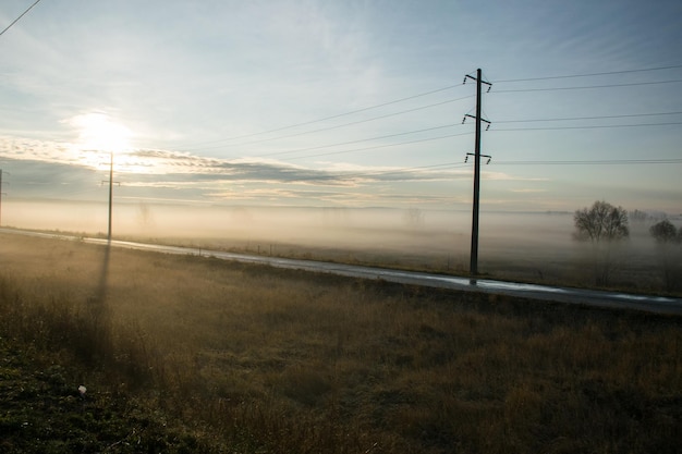 Nevoeiro na estrada ao longo do campo ao amanhecer nevoeiro no campo de outono ao longo da estrada Ulyanovsk