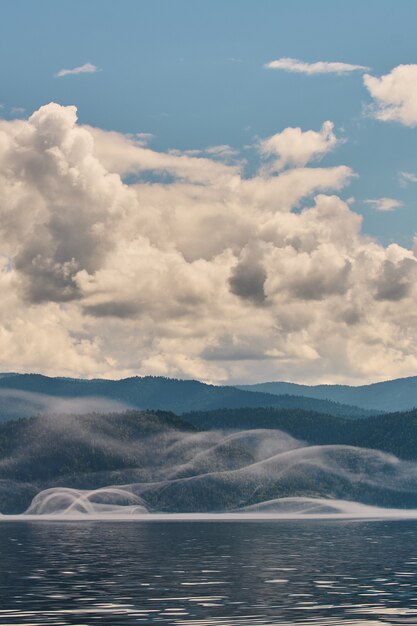 Nevoeiro no vale da montanha. Névoa da manhã sobre o lago nas montanhas Altai.