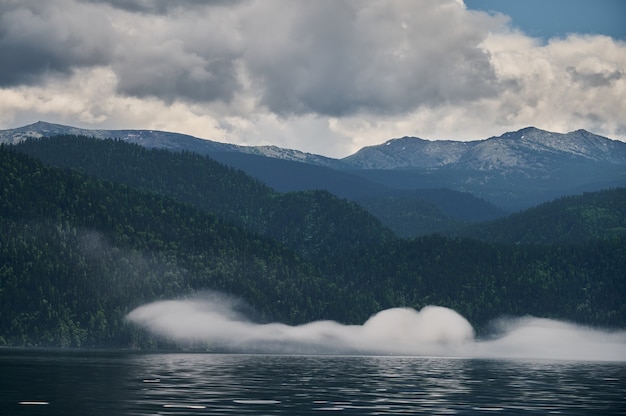 Nevoeiro no vale da montanha. Névoa da manhã sobre o lago nas montanhas Altai.